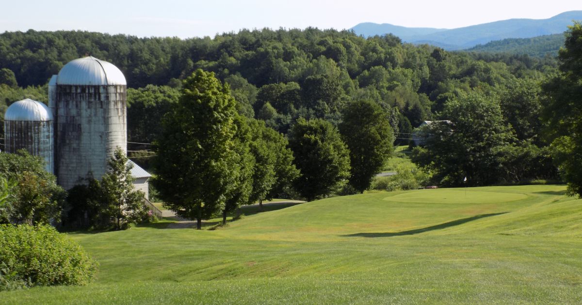 golf course with farm building nearby