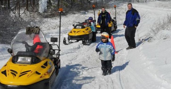 kid and people near snowmobiles