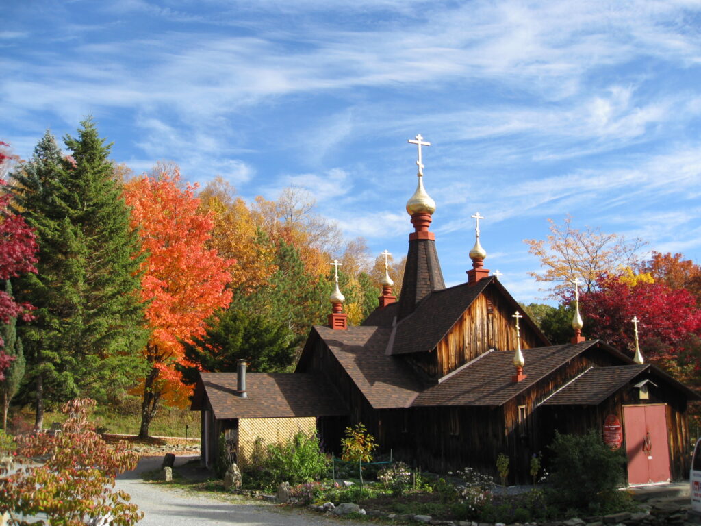 A church with vibrant trees in the background surrounding it