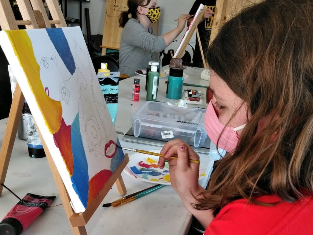 girl painting on an easel as summer activities for kids near Saratoga