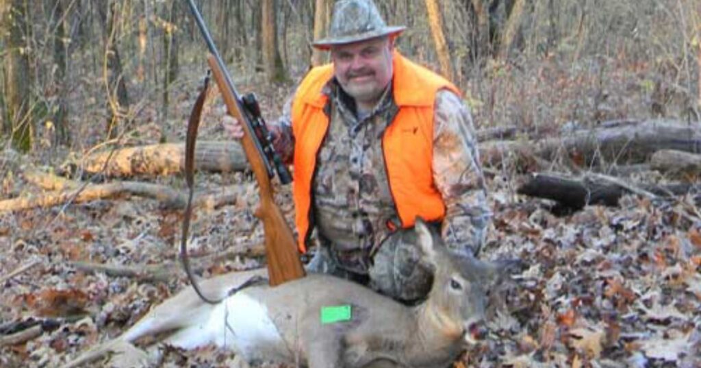 hunter with a gun and deer on ground