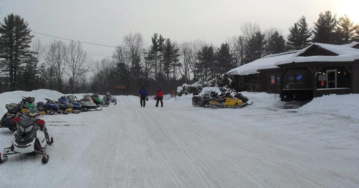 outside of boar's nest bar in winter with snowmobiles