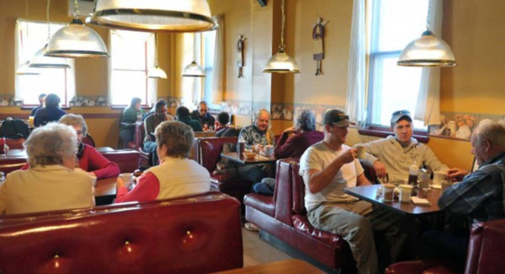 Several people sitting inside of Ginny Raes enjoying coffee and food.