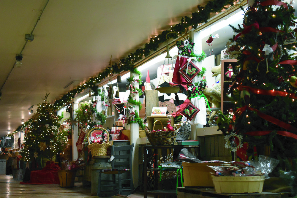 Interior of a store wall decorated with Christmas ornaments and several Christmas items that can be purchased.