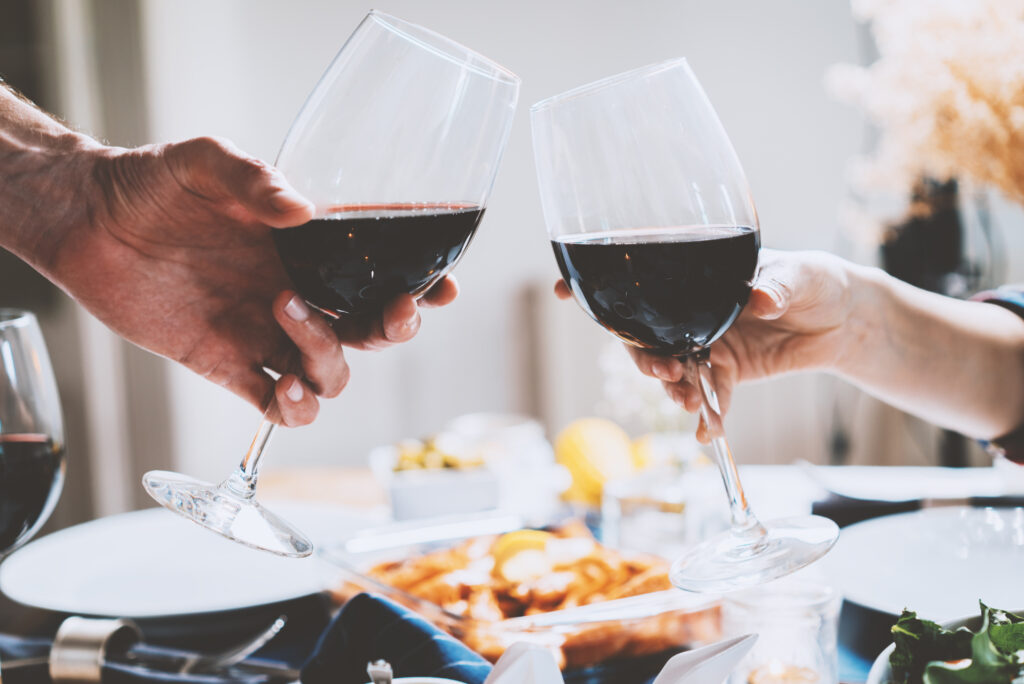 Two people cheering with wine glasses.